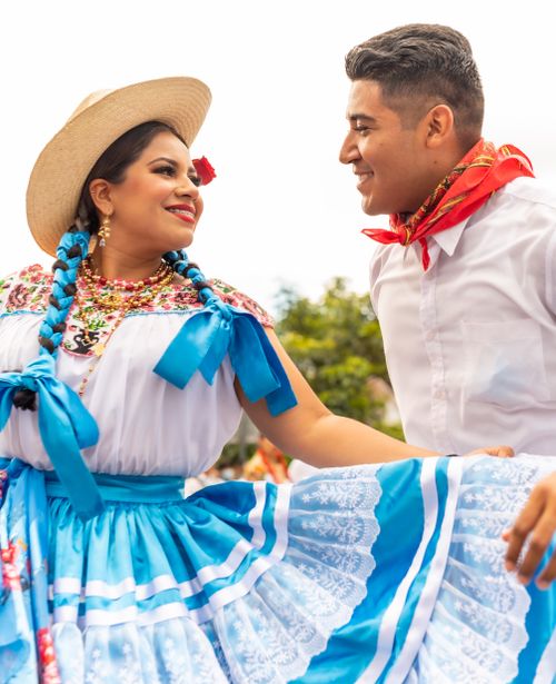 Free Happy couple in colorful traditional clothing celebrating outdoors with bright smiles. Stock Photo