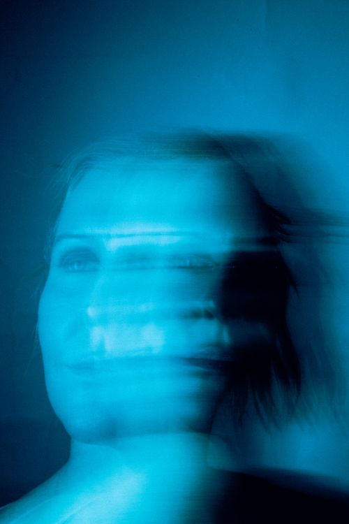 Free Abstract blurred portrait of a woman with blue tones creating a mysterious vibe. Stock Photo