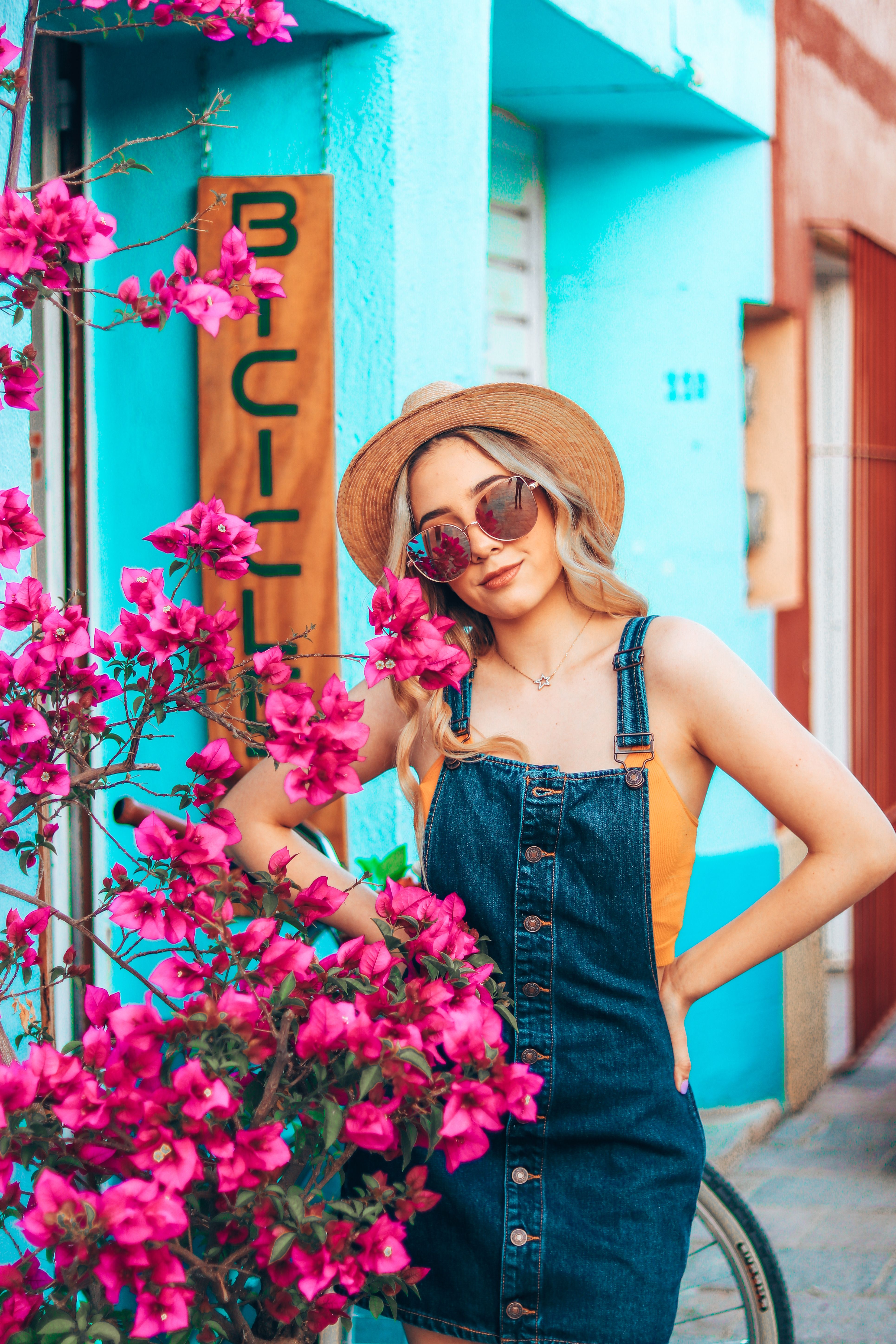 [ColoSach]-stylish-woman-in-denim-and-hat-posing-by-vibrant-flowers-in-oaxaca.-perfect-for-fashion-and-travel-themes.