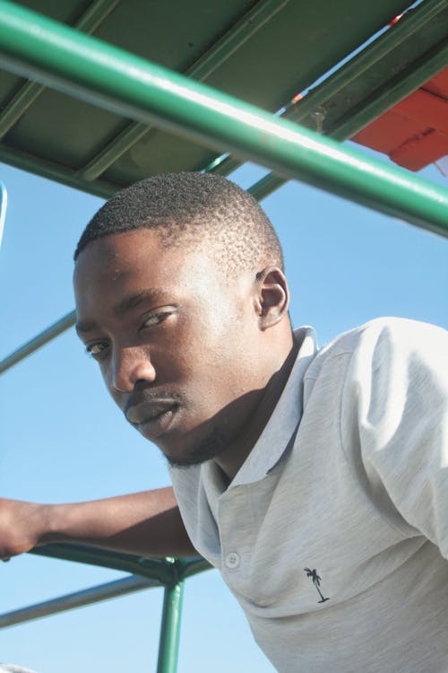 Young Man in a T-shirt Standing Outdoors in Sunlight 