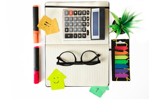 Desk with notebook and calculator with colorful notes. Colorful stickers and markers. Office work and school studies. Elements on an isolated white background.