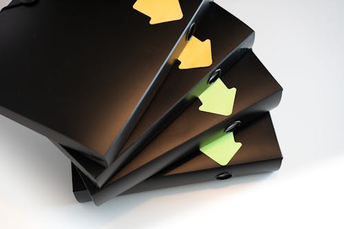 Black folders with documents and contracts isolated on a white background. Segregated with stickers in the shape of arrows. Workflow direction. Office work and household bills.
