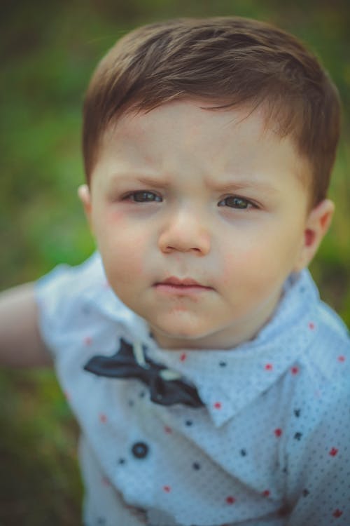 Photographie De Mise Au Point Sélective De Bébé Portant Une Chemise Blanche Et Rouge