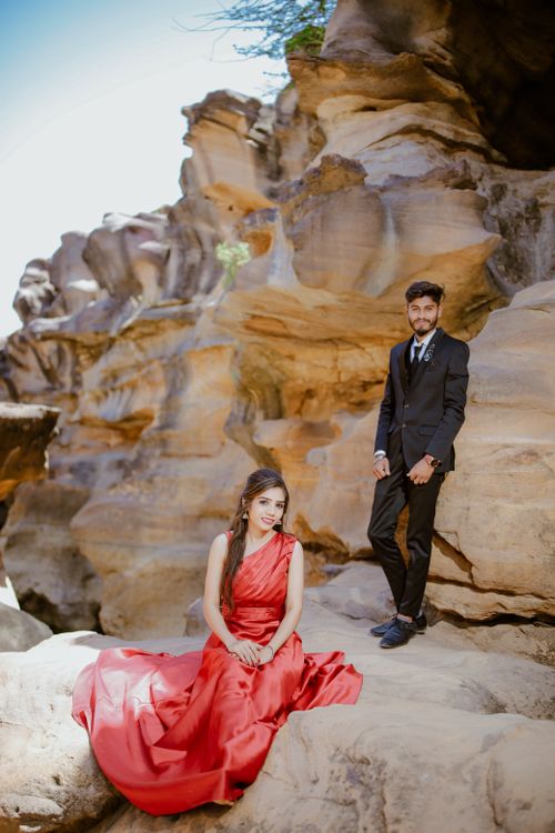 Free Elegant couple in formal attire posing amidst striking rock formations in Bhuj, India. Stock Photo