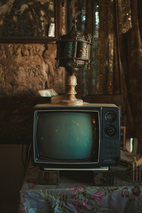 Free Old television with ornate lamp on top in vintage styled room. Stock Photo