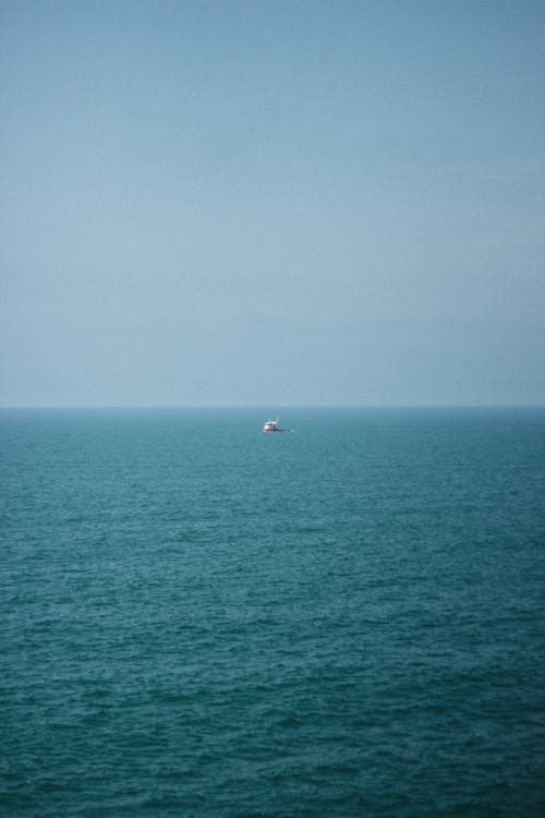 A Boat on the Sea under Clear Blue Sky 