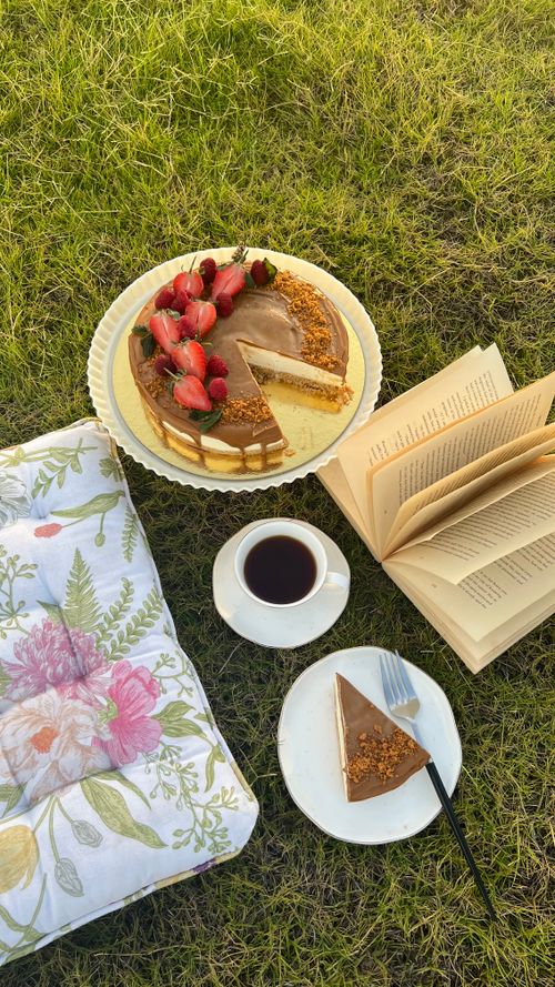 Free Enjoy a serene outdoor picnic with coffee, cake, and a good book on a sunny day. Stock Photo