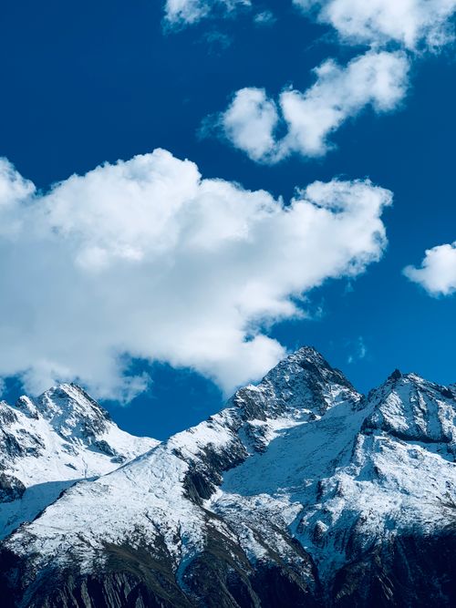 Free Scenic view of snow-covered mountain peaks in Leh under a bright, clear blue sky with clouds. Stock Photo