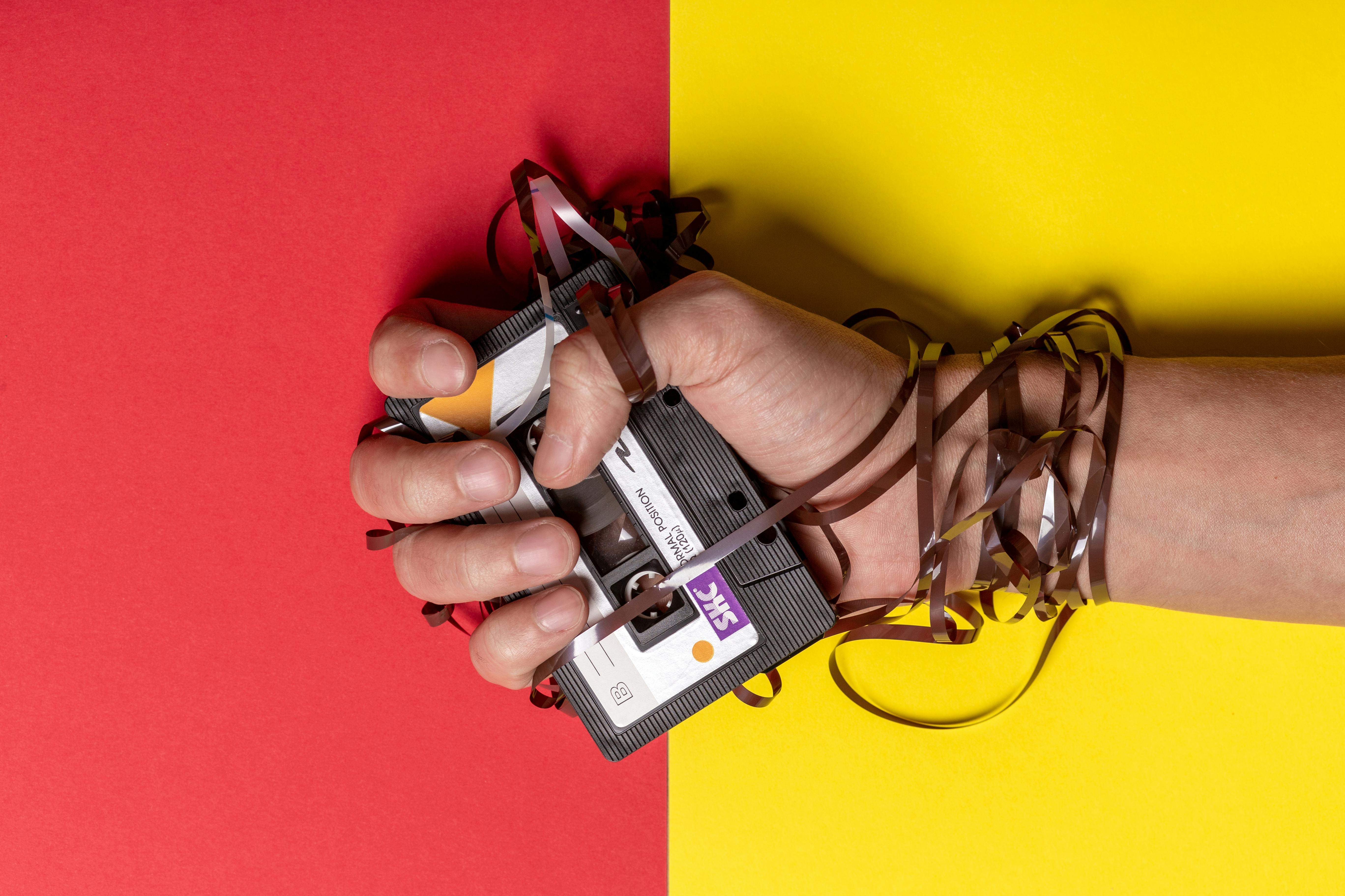 person holding black cassette tape