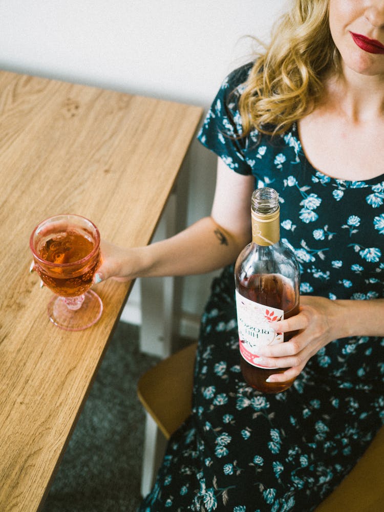 Blonde Woman Holding Wine Bottle And Glass