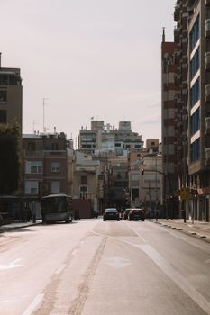 Street scene of cityscape with cars and buses in Valencia, Spain.