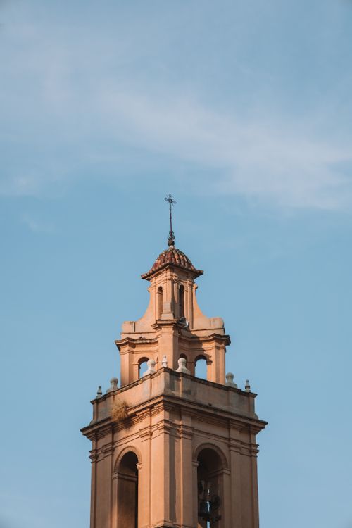 Free Close-up of a church tower in Valencia, Spain, set against a clear blue sky. Stock Photo