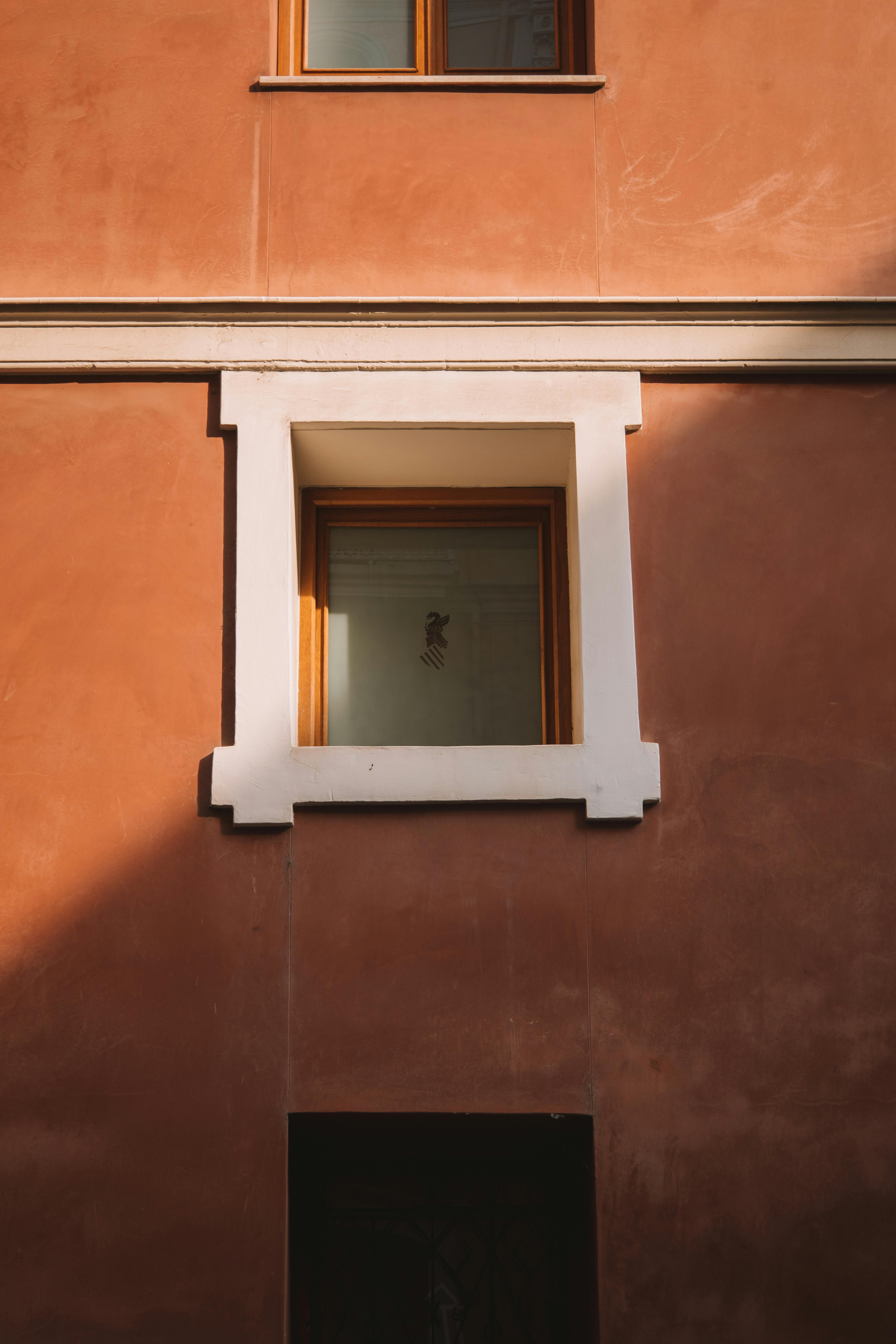 Sunlit facade of a residential building in Valencia, showcasing classic architectural elements.