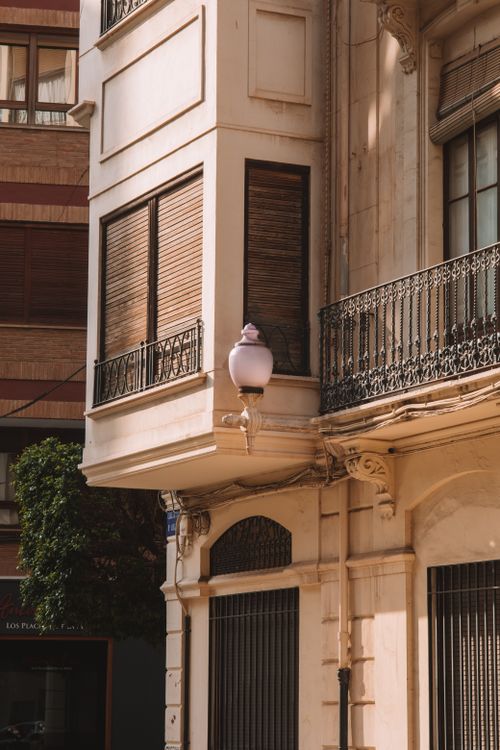 Free Elegant architectural detail of a historic building facade with balconies and ornate lamp in Valencia, Spain. Stock Photo