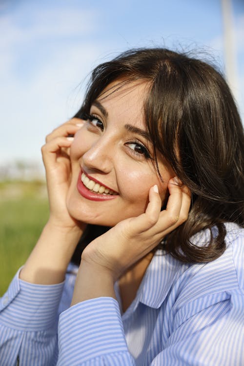 Smiling Woman Posing with Hands on Cheeks