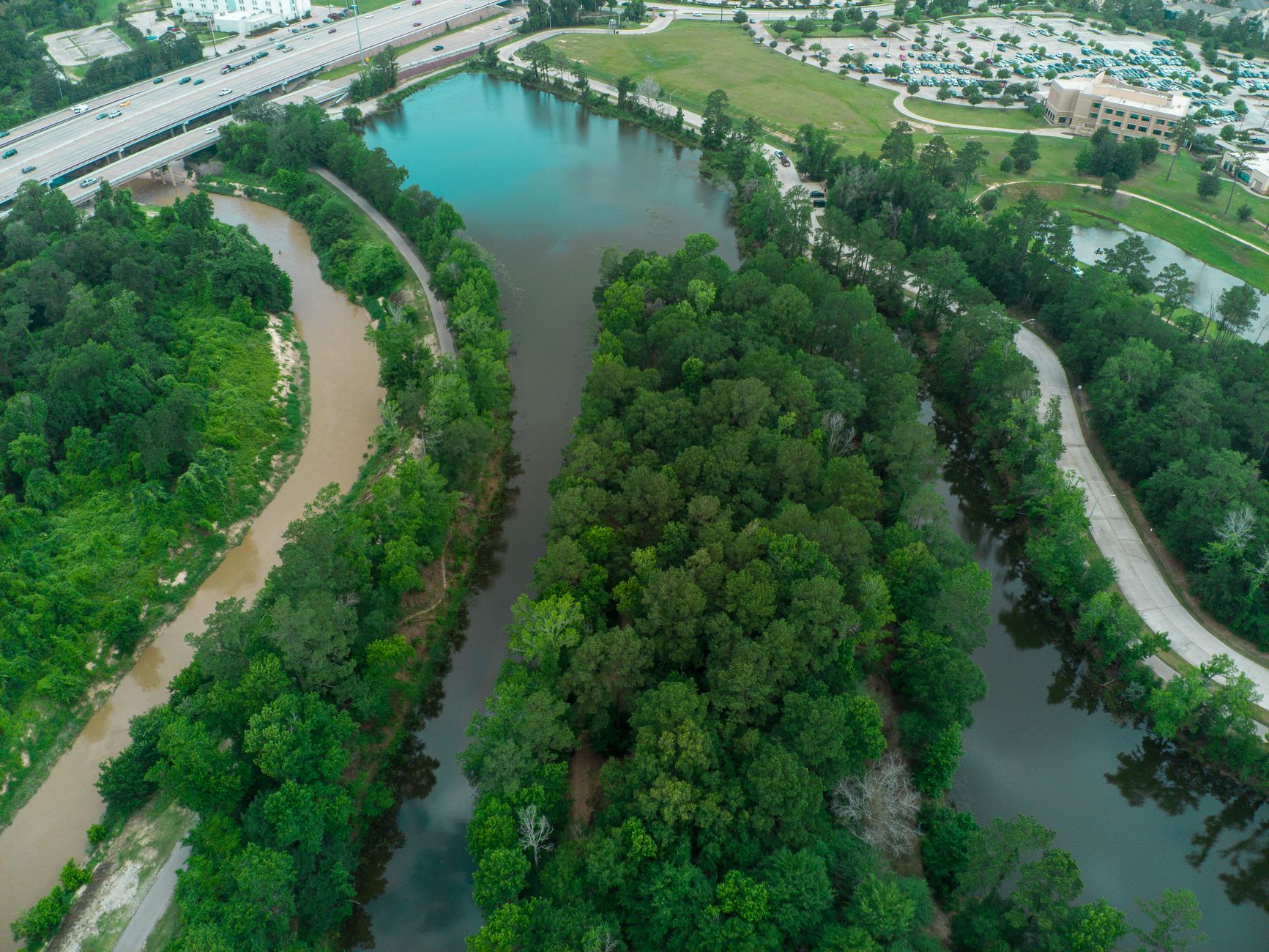 Captivating aerial shot of lush green rivers and urban landscape in Houston, TX during summer.