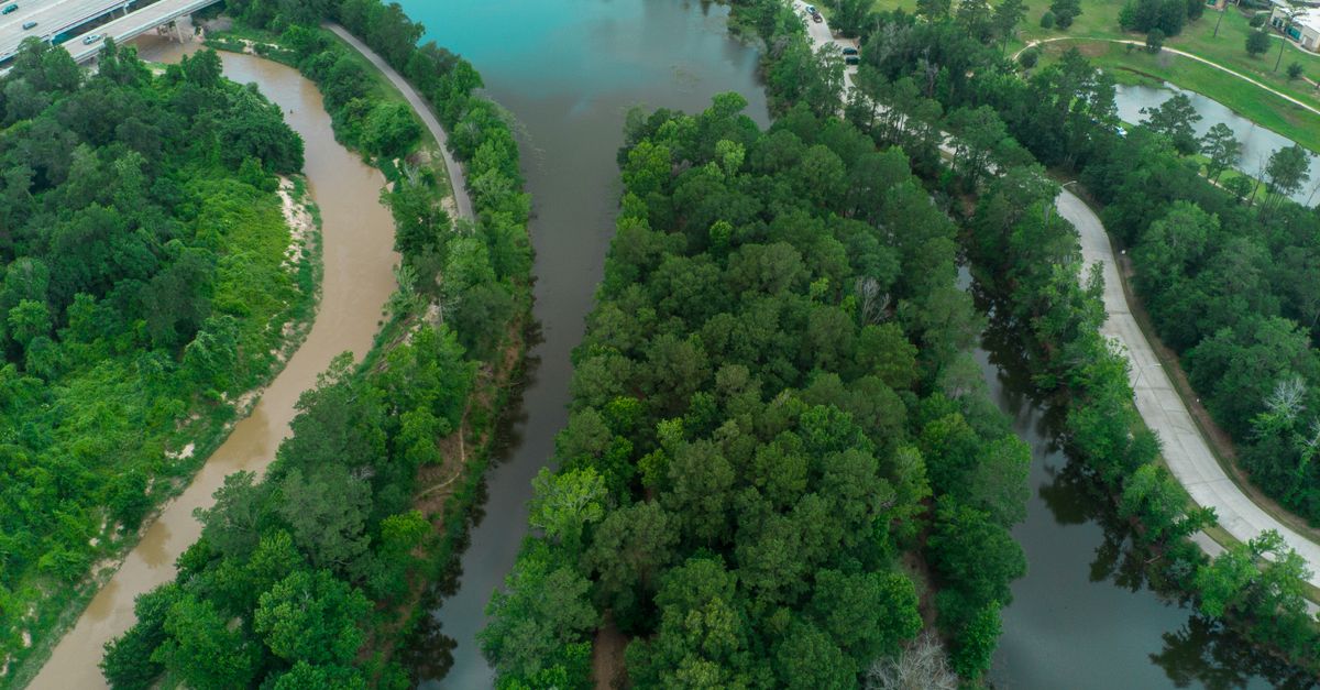 Captivating aerial shot of lush green rivers and urban landscape in Houston, TX during summer.