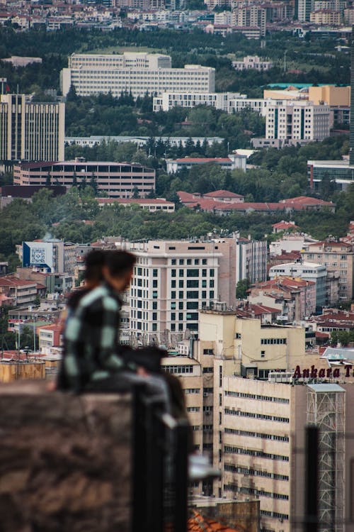 Apartment Buildings with People Sitting on a Rooftop in the Foreground