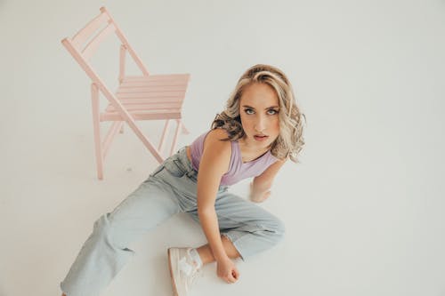 Blonde Woman Sitting near Chair