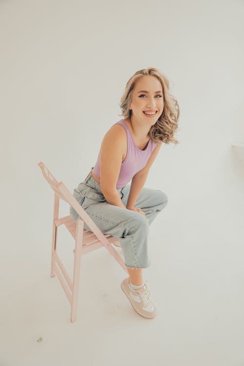 Smiling Blonde Woman Sitting on Chair