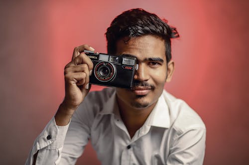 Man Posing with Camera in Studio