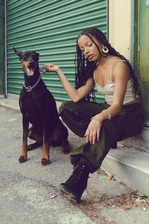 Free A fashionable woman poses with a Doberman on city streets, blending style with urban energy. Stock Photo
