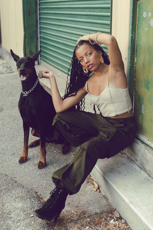 Free Stylish woman poses with Doberman against urban backdrop, showcasing street fashion. Stock Photo