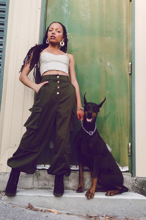 Free A stylish woman poses confidently with her Doberman outdoors against a rustic door. Stock Photo