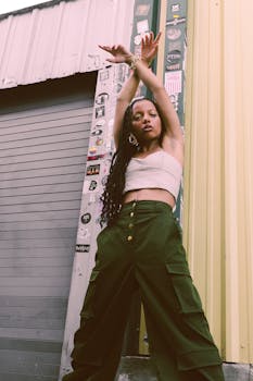 Stylish woman posing confidently against an urban street backdrop, showcasing modern street fashion.
