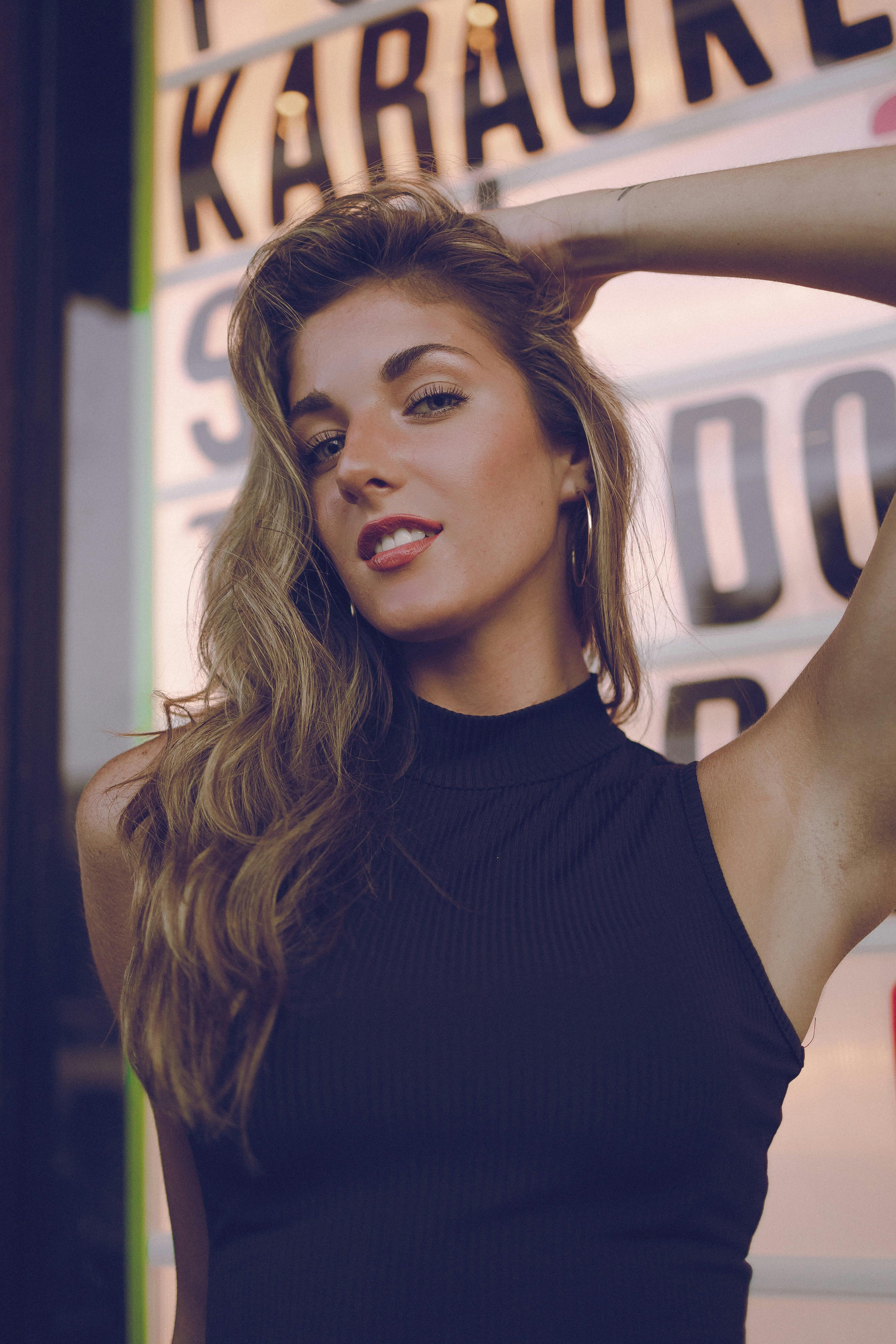 Fashionable woman posing confidently outdoors with a retro background.