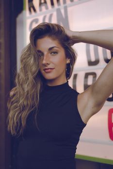 Elegant portrait of a woman posing confidently with a chic urban backdrop.