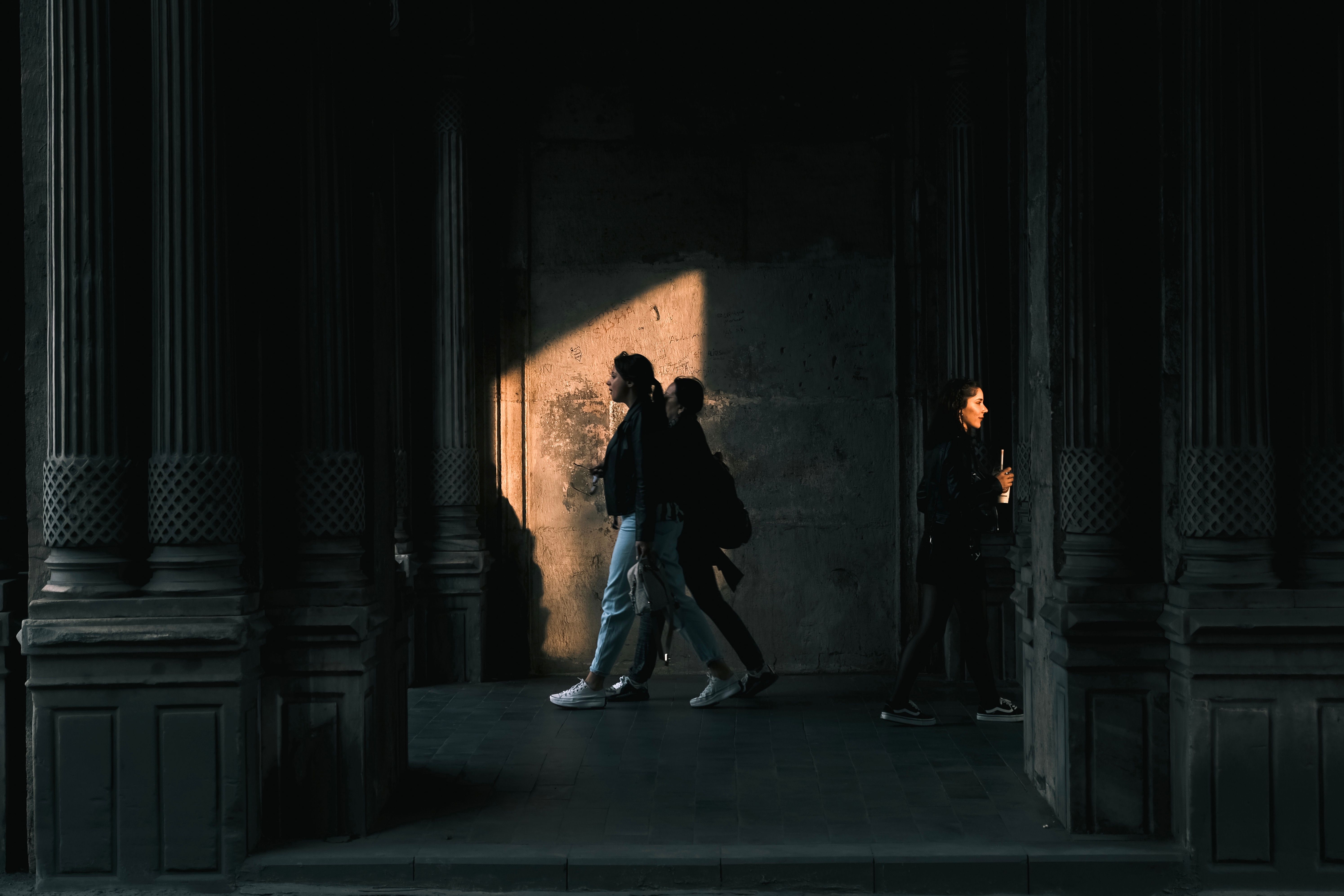 Women Walking near Wall in Shadow · Free Stock Photo