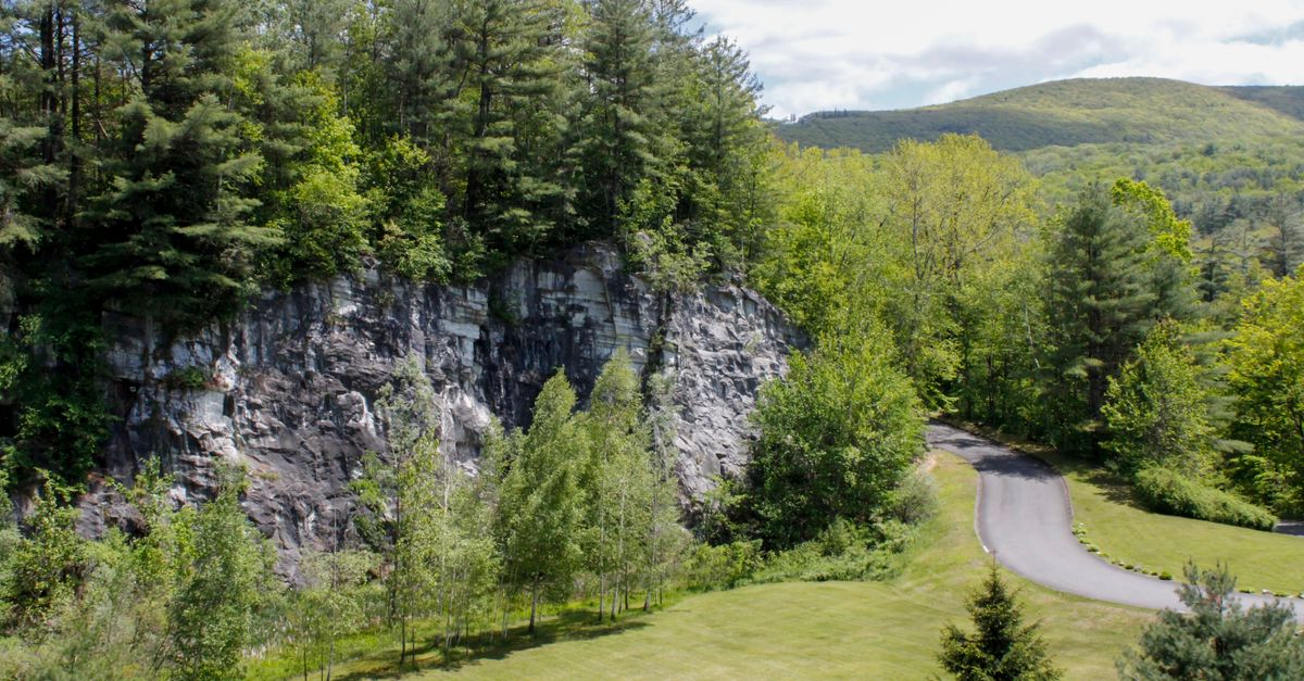 Captivating aerial shot of lush greenery and rocky cliff in North Adams, MA, USA.
