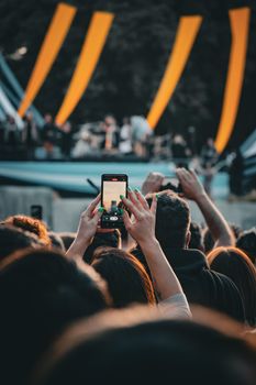 Crowd at a live concert in Mendoza capturing the moment on a cellphone at night.