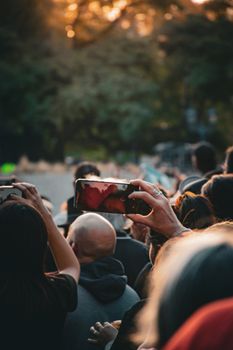 A crowd uses cellphones to capture an outdoor event at sunset in Mendoza, Argentina.