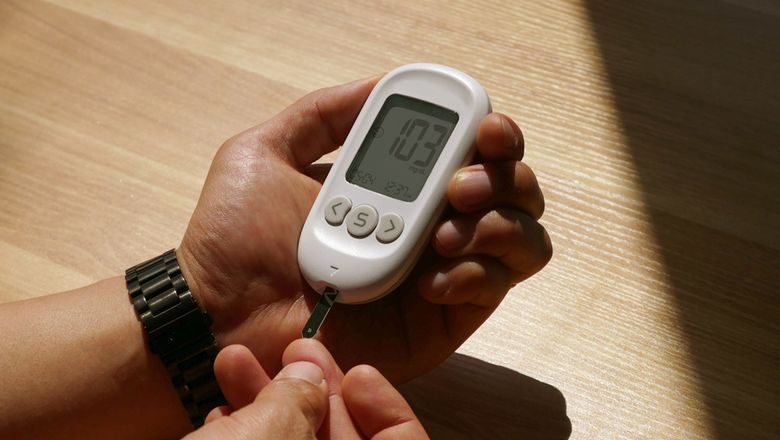 Person checking blood glucose with a meter