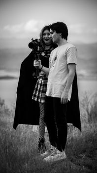 A couple collaborates on an outdoor film project using a camera on a gimbal.