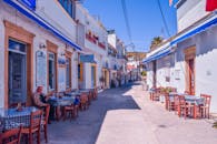 在明亮的蓝天下，风景如画的小巷里，传统咖啡馆设有户外座位