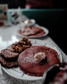 Close-up of a breakfast plate with pancakes, butter, and sausage, ideal for food lovers.