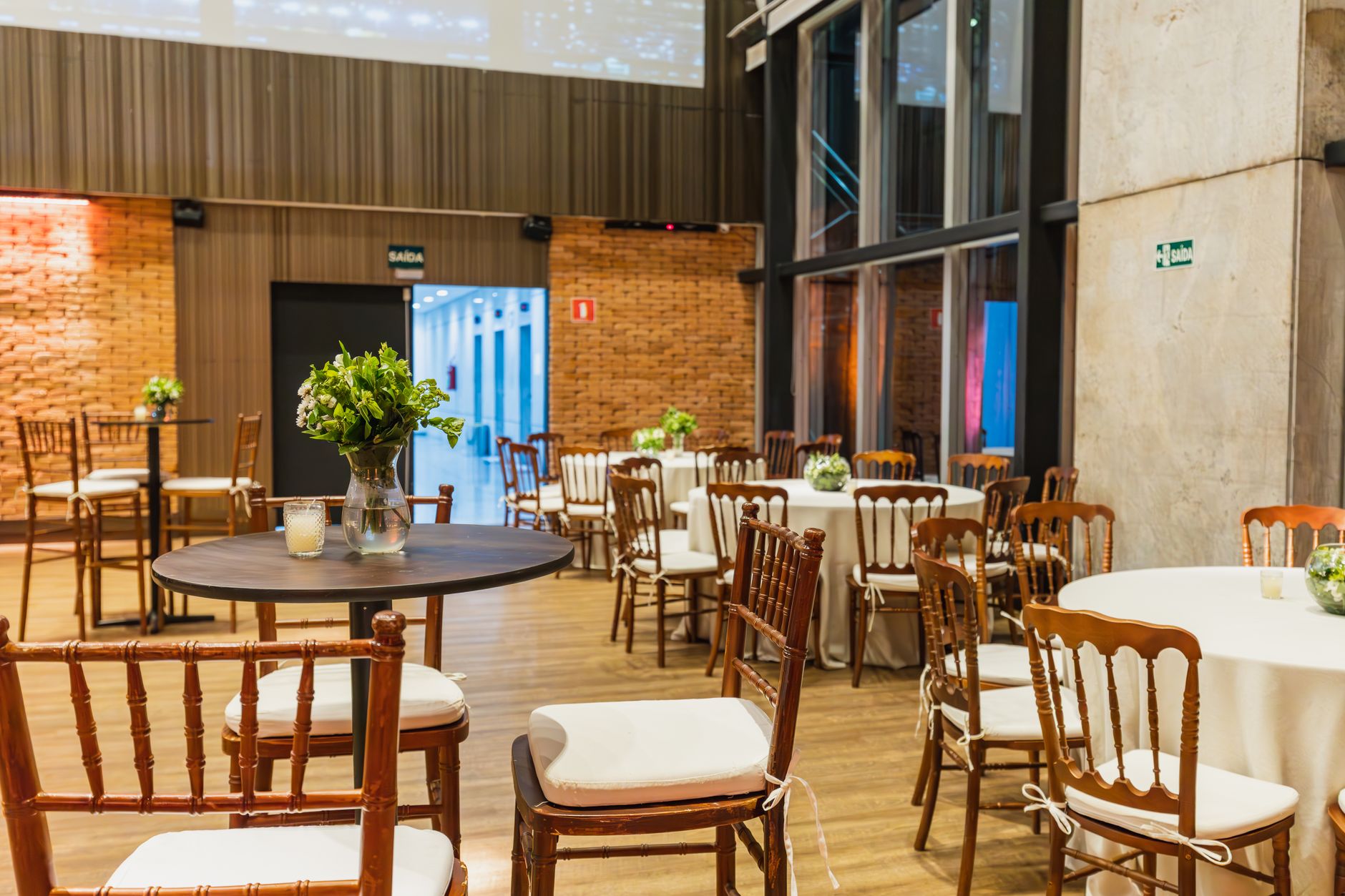 Beautifully decorated hall with wooden chairs and tables, perfect for celebrations and events.