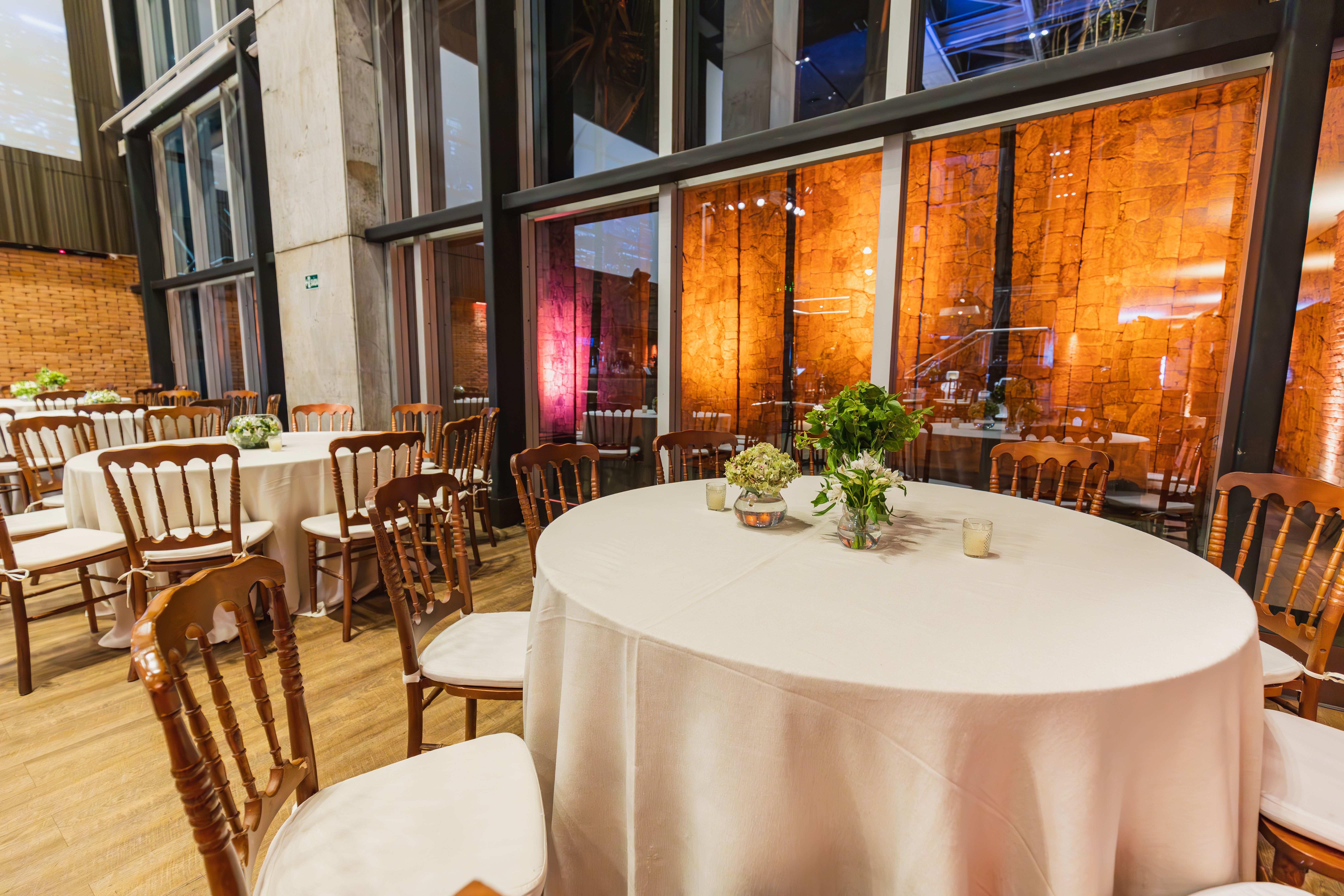 Beautifully decorated reception hall with round tables and floral centerpieces, perfect for events.