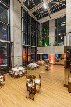 Spacious indoor event space with elegant decor, large windows, and ambient lighting in a modern setting.
