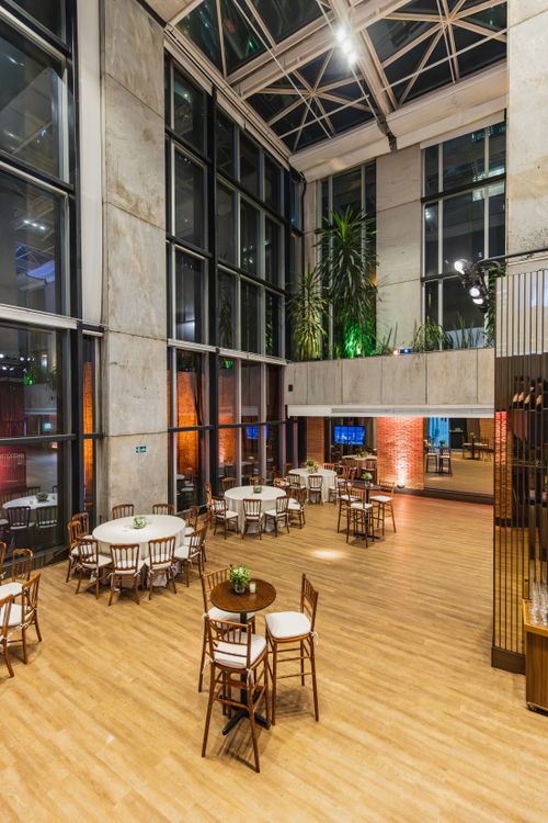 Free Spacious indoor event space with elegant decor, large windows, and ambient lighting in a modern setting. Stock Photo