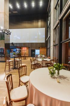 Spacious banquet hall with round tables and floral decor, ideal for celebrations or gatherings.