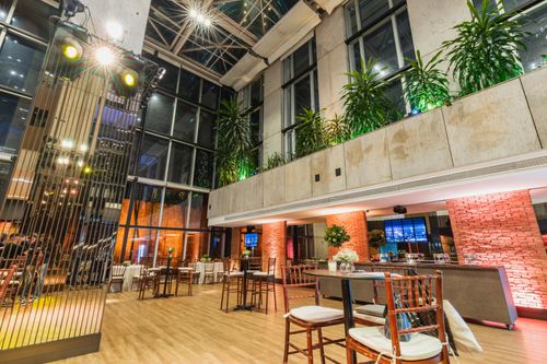 Free Spacious modern venue with elegant seating, lighting, and green plants for events and celebrations. Stock Photo