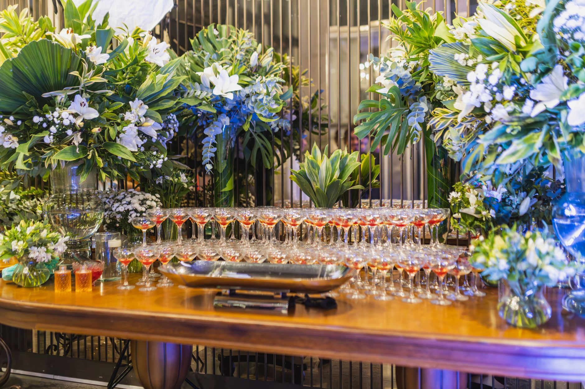 Beautifully decorated table with floral arrangements and champagne glasses at an indoor celebration.
