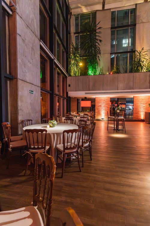 Free Sophisticated event venue with tables set, ready for a gathering or celebration. Stock Photo