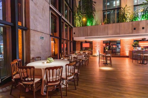 Free Spacious and elegant restaurant interior with tables set for dining. Contemporary decor enhances ambiance. Stock Photo