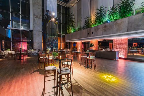 Free Luxurious modern banquet hall with ambient lighting, wooden floors, and stylish decor. Stock Photo