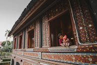 一位父亲在一座装饰复杂的传统建筑中抱着他的孩子，展示文化建筑